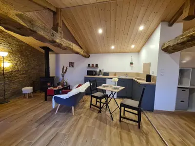 a kitchen and living room with a table and chairs at Refuge Insolite avec balnéo privative en forêt in Pont-de-Larn