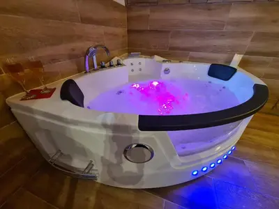 a white bath tub with purple lights in a bathroom at Refuge Insolite avec balnéo privative en forêt in Pont-de-Larn