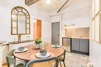 a kitchen and dining room with a wooden table and chairs at El Quatro - Wifi - Central - tout équipé in Carcassonne