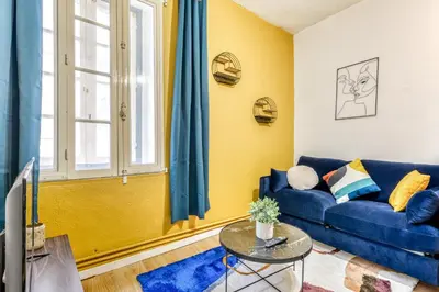 a living room with a blue couch and a table at El Quatro - Wifi - Central - tout équipé in Carcassonne