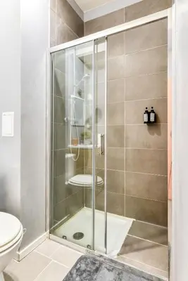 a shower with a glass door in a bathroom at El Quatro - Wifi - Central - tout équipé in Carcassonne