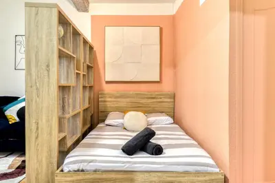 a bed in a room with wooden shelves at El Quatro - Wifi - Central - tout équipé in Carcassonne