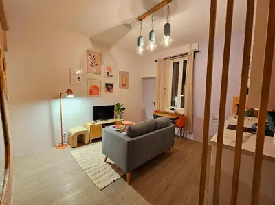 a living room with a couch and a table at Le Pastel YourHostHelper in Narbonne
