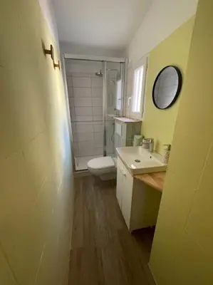 a bathroom with a toilet and a sink and a mirror at Le Pastel YourHostHelper in Narbonne