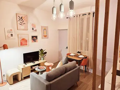 a living room with a couch and a table at Le Pastel YourHostHelper in Narbonne