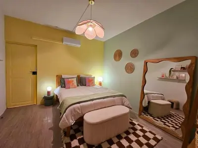 a bedroom with a large bed and a chandelier at Le Pastel YourHostHelper in Narbonne