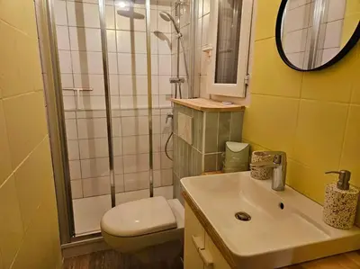 a bathroom with a shower and a toilet and a sink at Le Pastel YourHostHelper in Narbonne