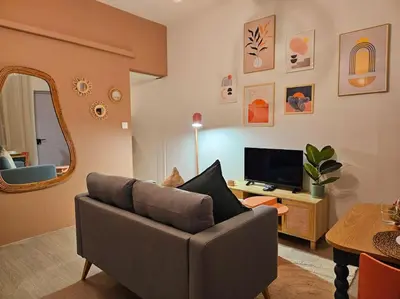 a living room with a couch and a television at Le Pastel YourHostHelper in Narbonne