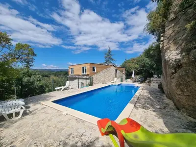 a swimming pool in front of a house at La Roche 10 in Aigues-Vives