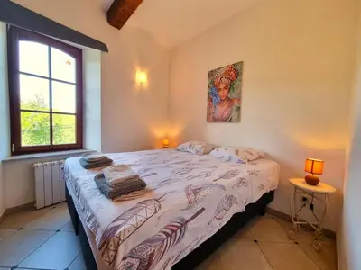 a bedroom with a bed in a room with a window at La Roche 10 in Aigues-Vives
