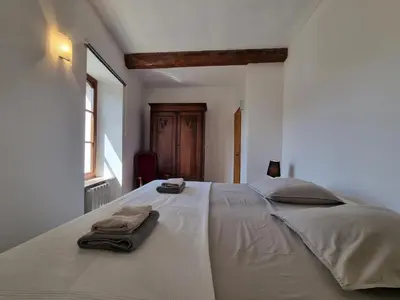 a bedroom with a large white bed with towels on it at La Roche 10 in Aigues-Vives
