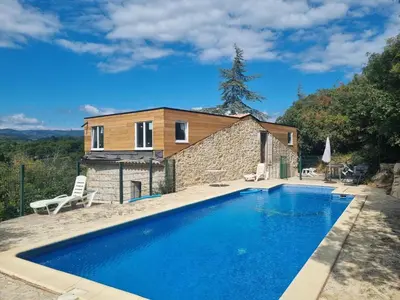 a villa with a swimming pool in front of a house at La Roche 10 in Aigues-Vives