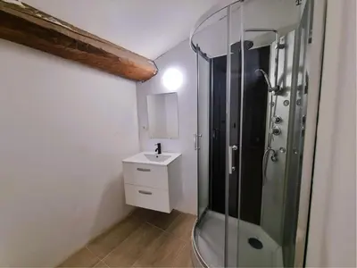 a bathroom with a glass shower and a sink at La Roche 8 in Aigues-Vives