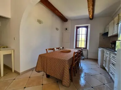 a kitchen with a table and chairs in a kitchen at La Roche 8 in Aigues-Vives