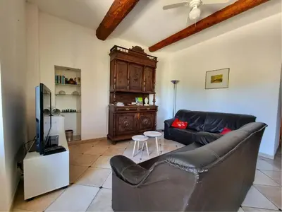 a living room with a black couch and a tv at La Roche 8 in Aigues-Vives