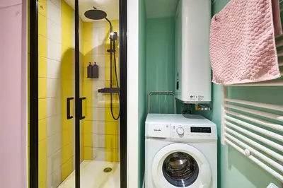 a bathroom with a washing machine and a shower at La Villa Orange - Instagood - proche cité médiévale et centre ville à pied in Carcassonne