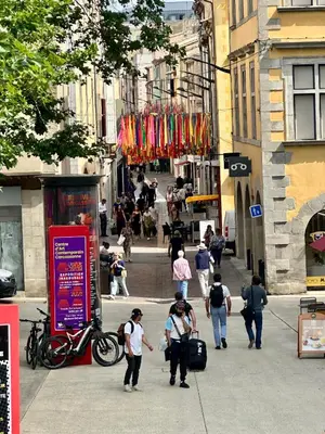 a group of people walking down a city street at La magie de Carnot Meublé de tourisme 3 étoiles in Carcassonne