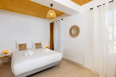 a white bedroom with a white bed in a room at L'Impasse d'Adam Free Parking in Carcassonne