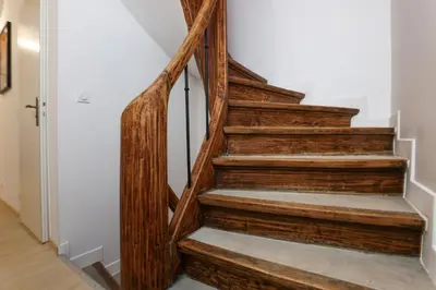 a wooden staircase in a home with a white wall at L'Impasse d'Adam Free Parking in Carcassonne