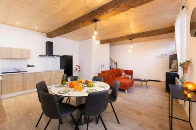 a dining room and living room with a table and chairs at L'Impasse d'Adam Free Parking in Carcassonne