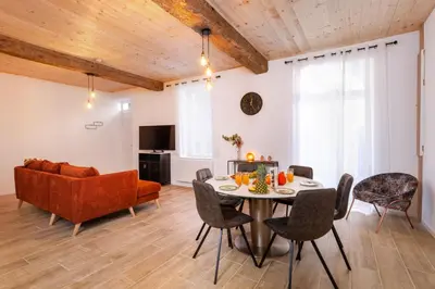 a living room with a table and chairs and a couch at L'Impasse d'Adam Free Parking in Carcassonne