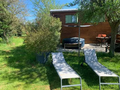 two benches in the grass in front of a cabin at Roulotte et Nature in Mirepoix