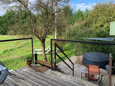 a wooden deck with a fence and a tree at Roulotte et Nature in Mirepoix