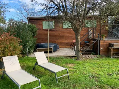 two chairs sitting in the grass in front of a house at Roulotte et Nature in Mirepoix