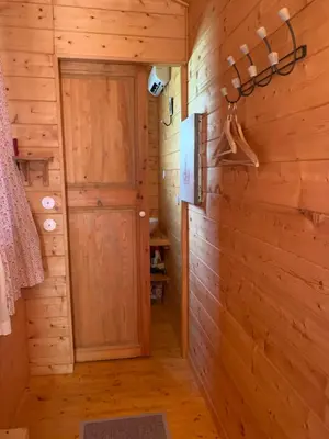 a hallway in a wooden cabin with a door at Roulotte et Nature in Mirepoix