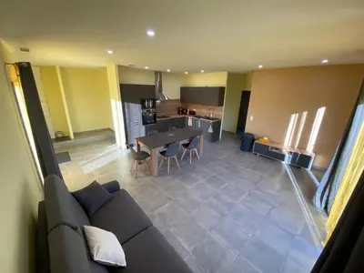a living room and kitchen with a couch and a table at T3 Gîte le Canigou in Trévillach