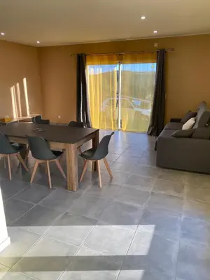 a living room with a table and chairs and a couch at T3 Gîte le Canigou in Trévillach