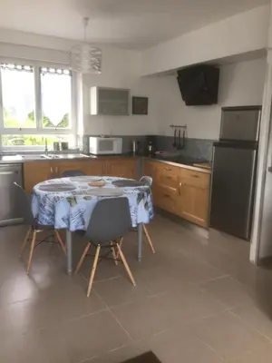 a kitchen with a table with chairs and a refrigerator at Chez Domi in Trèbes