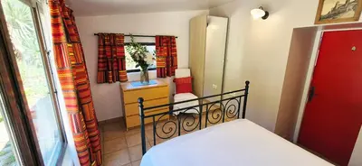 a small bedroom with a bed and a mirror at Au Pont Romain Gites in Caunes-Minervois