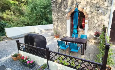 a table and chairs in front of a building at Au Pont Romain Gites in Caunes-Minervois