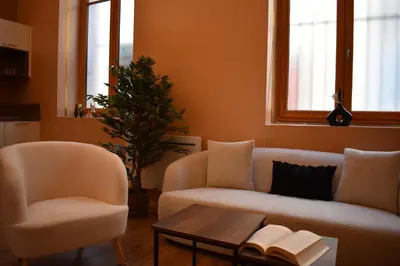 a living room with two chairs and a couch and a table at La République d'Emmanuel in Carcassonne