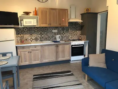 a kitchen with wooden cabinets and a blue couch at Moulin de Perle in Fosse