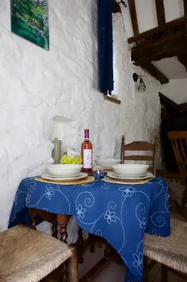 a blue table with plates and a bottle of wine at Moulin de Perle in Fosse