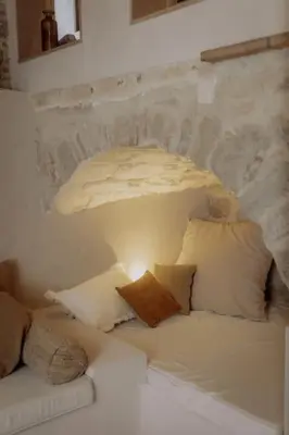a white couch with pillows and a light on it at Pausette in Fanjeaux