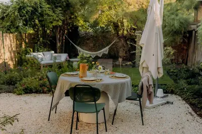 a table with chairs and an umbrella in a garden at Pausette in Fanjeaux