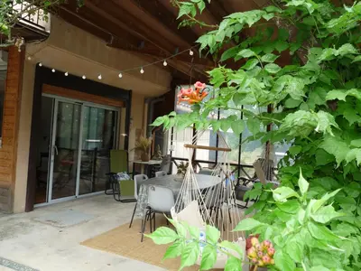 a patio with a table and chairs and a tree at Gîte de Lamourade in Saint-Ferriol