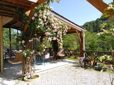 a patio with a table and chairs and a swing at Gîte de Lamourade in Saint-Ferriol