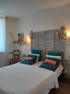 a bedroom with a large white bed with blue pillows at Appartement au coeur du centre historique in Narbonne