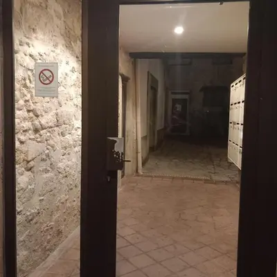 an empty hallway with a no smoking sign on a wall at Appartement au coeur du centre historique in Narbonne