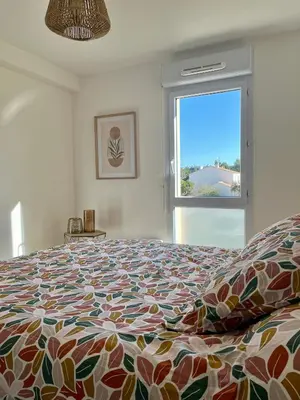 a bedroom with a large bed and a window at Narb'home, Cosy , Parking, Balcon in Narbonne