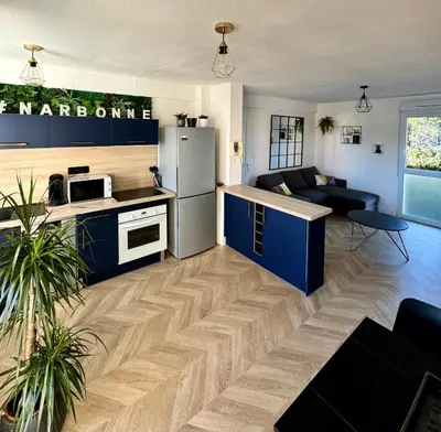 a kitchen with a refrigerator and a living room at Narb'home, Cosy , Parking, Balcon in Narbonne