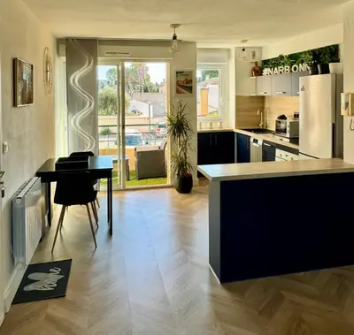 a kitchen with a table and a counter top at Narb'home, Cosy , Parking, Balcon in Narbonne