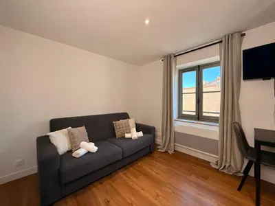 a living room with a couch and a window at Le Baroque Studio Wifi in Narbonne