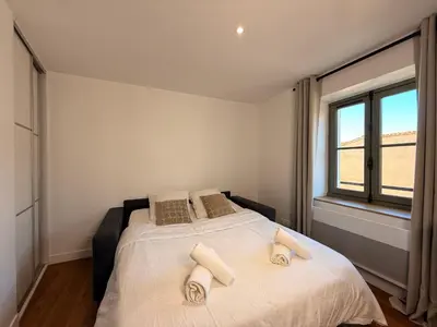 a bedroom with a large bed with towels on it at Le Baroque Studio Wifi in Narbonne