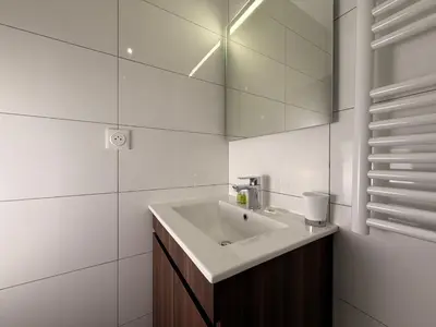 a white bathroom with a sink and a mirror at Le Baroque Studio Wifi in Narbonne
