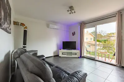 a living room with a leather couch and a television at L'Écrin de Pamiers - Appt climatisé pour 6 in Pamiers